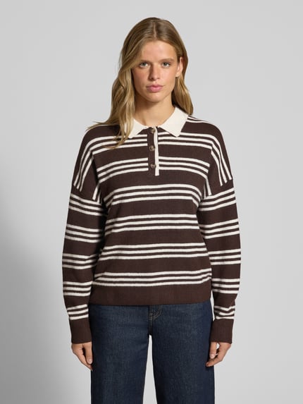 Frauenmodel trägt Oversized Strickpullover mit Polokragen von REVIEW, braun mit weißen Streifen, Material-Mix, Allover-Look, Ganzkörperansicht von vorne.