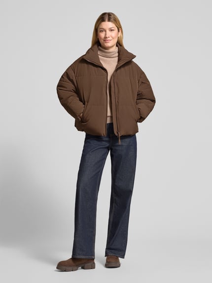 Frauenmodel trägt Steppjacke mit Stehkragen Modell 'Refron' von MSCH Copenhagen in Braun mit Eingrifftaschen, Regular Fit, Ganzkörperansicht von vorne.