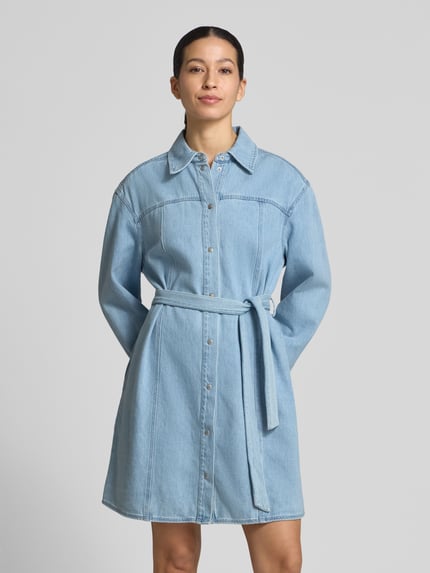 Frauenmodel trägt Knielanges Jeanskleid mit Bindegürtel Modell 'Kimmia' von mbyM aus Baumwoll-Mix, Gerader-Schnitt, Hemdblusenkragen, Knielänge, Ganzkörperansicht von vorne.