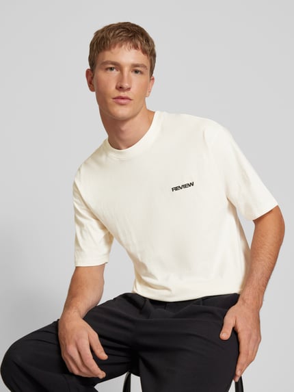 Männermodel trägt Relaxed Fit T-shirt uit puur katoen van REVIEW met geborduurd logo, heren, witte tinten, nahaufnahme bovenlichaam. Ruglengte maat M: 68 cm.