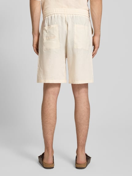 Männermodel trägt Leinenshorts mit elastischem Bund und Tunnelzug von ANOTHER COTTON LAB, Regular-Fit, reine Leinen, Rückansicht.