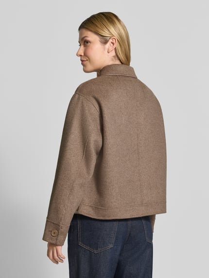 Frauenmodel trägt Hemdjacke aus Woll-Mix mit Eingrifftaschen von Smith and Soul, prosty krój, kołnierzyk typu kent, listwa guzikowa, wpuszczane kieszenie, długość tyłu w rozmiarze S: 58 cm, szerokość ramion w rozmiarze S: 44 cm, szerokość klatki piersiowej w rozmiarze S: 60 cm, długość rękawów w rozmiarze S: 57 cm, odcień brązu, tekstura mieszanki wełny, gładka powierzchnia, Ganzkörperansicht Rückansicht.