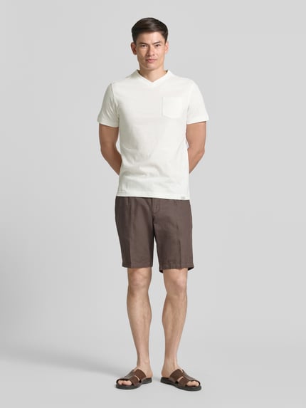 Männermodel trägt Regular Fit T-Shirt mit V-Ausschnitt von Lerros aus weißer Baumwolle mit Brusttasche und Logo-Stitching, Ganzkörperansicht von vorne.