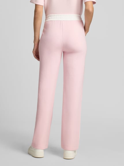 Frauenmodel trägt Straight Fit Hose mit Tunnelzug von Marc Cain, Damen Hose mit elastischem Bund in Rosa, Ganzkörperansicht Rückansicht.