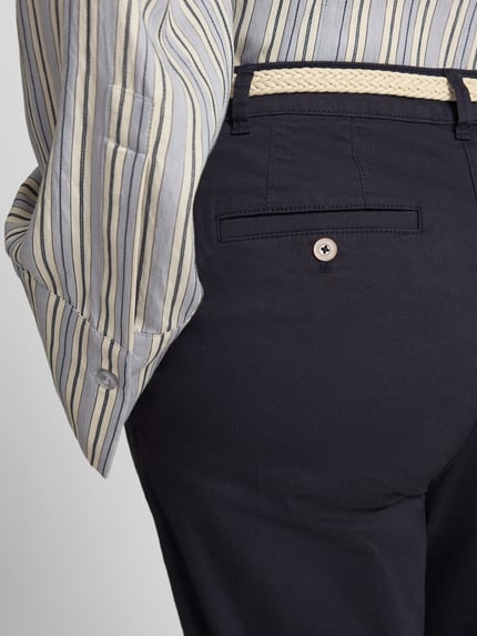 Frauenmodel trägt Chino aus Baumwoll-Mix mit verkürzter Passform von Christian Berg Woman, dunkelblau, integrierter Gürtel, Nahaufnahme Hüfte.