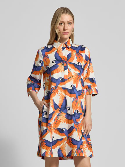 Modelka kobieca nosi knielanges Hemdblusenkleid im Allover-Look von Christian Berg Woman z bawełny, prosty krój, długość do kolan, wzór na całej powierzchni, ukryta listwa guzikowa, długość tyłu w rozmiarze 36: 96 cm, szerokość w rozmiarze 36: 51 cm, długość rękawów w rozmiarze 36: 35 cm, widok całej sylwetki z przodu.
