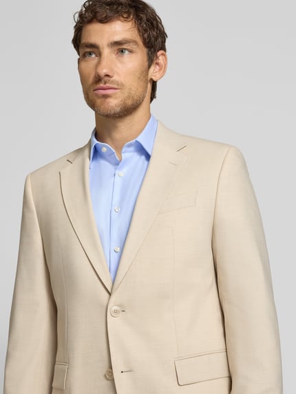 Männermodel trägt Regular Fit Sakko mit Schurwoll-Anteil Modell 'Jasper' von BOSS in Beige, glatte Struktur, Nahaufnahme Oberkörper.