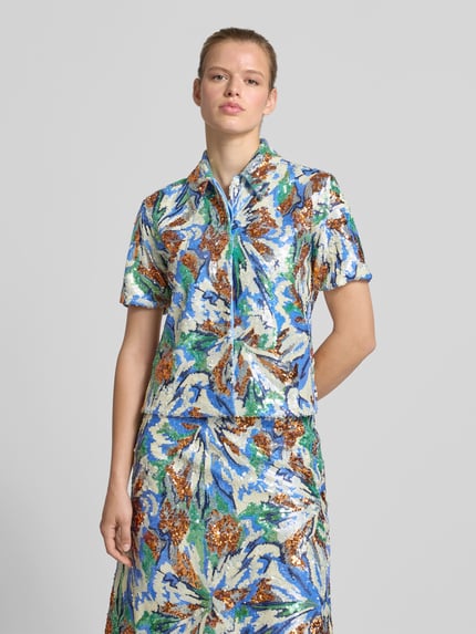 Frauenmodel trägt Hemdbluse mit Allover-Pailettenbesatz von Rabanne in Blau, Grün und Silber, taillierte Passform, Nahaufnahme Oberkörper.