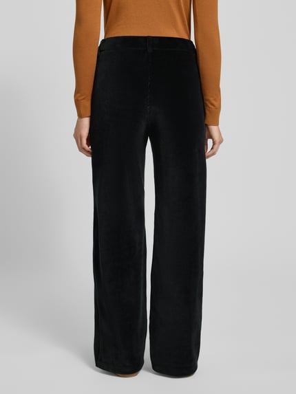 Vrouwenmodel draagt zwarte Cordhose met elastische tailleband en steekzakken, wijde pijpen, model 'MAINE' van Brax, volledig achteraanzicht.