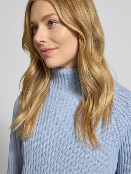 Frauenmodel trägt Strickpullover mit Woll-Anteil von Smith and Soul in Hellblau, gerippte Textur, Stehkragen, Nahaufnahme Oberkörper.