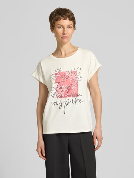 Frauenmodel trägt T-Shirt mit fixiertem Ärmelaufschlag Modell 'RINA' von Soyaconcept, Baumwoll-Mix, weiß mit Print, Ganzkörperansicht von vorne.