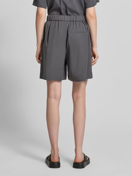 Kobiece model nosi szorty Straight Fit Shorts und Leinen-Anteil od Marc O'Polo, efekt: jednolity kolor, krój straight fit, bez zapięcia, elastyczny ściągacz, wpuszczane kieszenie boczne, widok całej sylwetki z tyłu.