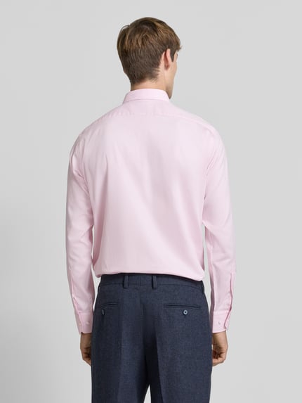 Männermodel trägt Regular Fit Businesshemd mit Kentkragen Modell 'H-JOE-K' von BOSS in Hellrosa, uni, glatte Textur, Ganzkörperansicht Rückansicht.
