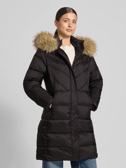 Modelka nosi czarny Daunenmantel mit Reißverschlusstaschen Modell 'Glenn' od ROCKANDBLUE, krój regular fit, kaptur z sztucznym futrem, ukryty zamek, kieszenie na zamek, długość tyłu w rozmiarze 36: 90 cm, szerokość ramion w rozmiarze 36: 42 cm, szerokość klatki piersiowej w rozmiarze 36: 48 cm, długość rękawa w rozmiarze 36: 62 cm, przód pełnej sylwetki.