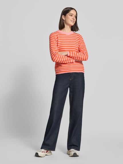 Frauenmodel trägt Regular Fit Strickpullover mit Woll-Anteil von ZABAIONE in Orange-Weiß, gerippte Abschlüsse, Ganzkörperansicht von vorne.