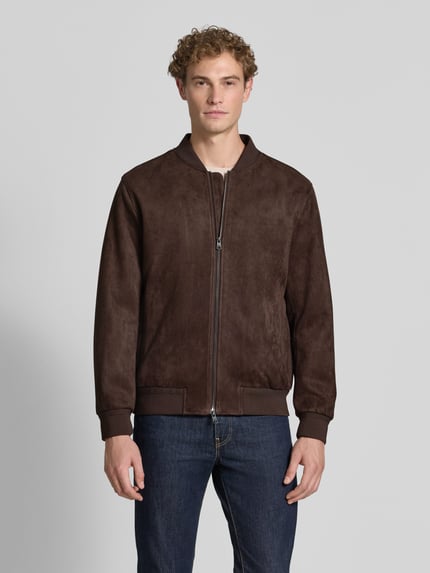 Męski model nosi Regular Fit Bomberjacke in Leder-Optik Model 'Rapid' od CINQUE, elastyczna mieszanka materiałów, stójka, zamek błyskawiczny dwustronny, elastyczne wykończenia, brązowy kolor, tekstura skóropodobna, Długość tyłu w rozmiarze M: 69 cm, szerokość ramion w rozmiarze M: 52 cm, szerokość klatki piersiowej w rozmiarze M: 63 cm, długość rękawów w rozmiarze M: 68 cm, ujęcie całej sylwetki z przodu.