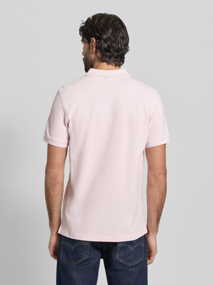 Männermodel trägt Slim Fit Poloshirt mit Logo-Stitching von MCNEAL in zartem Rosa, reine Baumwolle, Polokragen, Ganzkörperansicht Rückansicht.