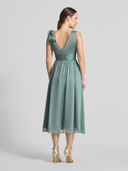 Frauenmodel trägt Cocktailkleid mit V-Ausschnitt von Swing in Taillierter Passform, Midilänge, Volants, Reißverschluss, Ganzkörperansicht Rückansicht.