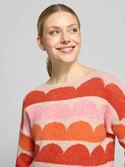 Frauenmodel trägt Relaxed Fit Strickpullover aus elastischem Woll-Mix von ZABAIONE, bunte Streifen in Rosa, Rot, Orange, Nahaufnahme Oberkörper, Damen Strickpullover Modell 'Ha44rlow', U-Boot-Ausschnitt, Rückenlänge 55 cm, Ärmellänge 53 cm