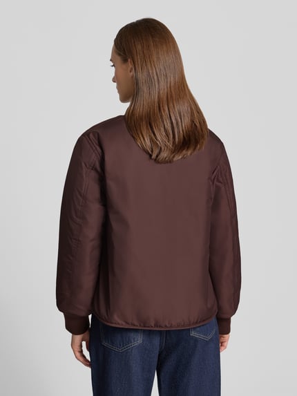 Frauenmodel trägt Regular Fit Blouson mit Wendefunktion von Marc O'Polo in Braun, glatte Struktur, Damen Bomberjacke, Ganzkörperansicht Rückansicht.