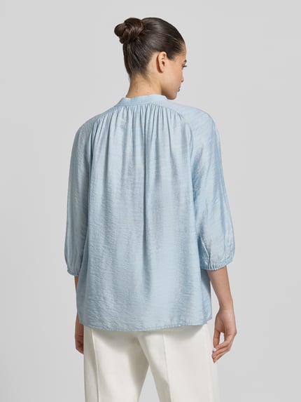 Vrouwenmodel draagt Regular Fit Bluse mit Schnürung und 3/4-Arm van Jake*s Collection in lichtblauw viscosemix, ruglengte 66 cm, mouwlengte 56 cm, mix van lichte en zachte textuur, ganzekörperaanzicht rugaanzicht.