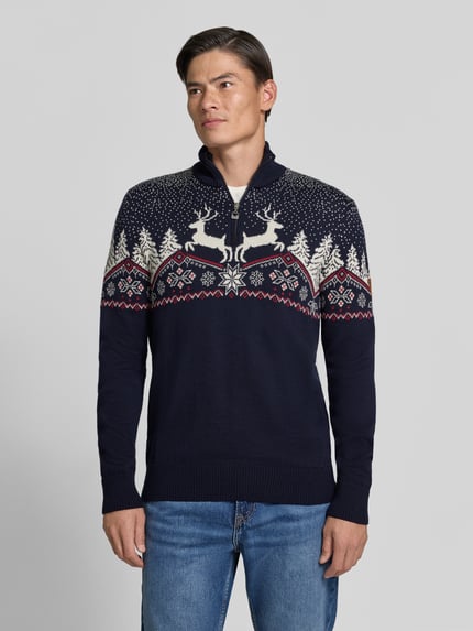 Männermodel trägt Regular Fit Strickpullover aus reiner Wolle Modell 'Dale' von Dale of Norway, Norweger-Muster, Ganzkörperansicht von vorne. Rückenlänge 72 cm, Ärmellänge 68 cm, Troyer-Kragen.