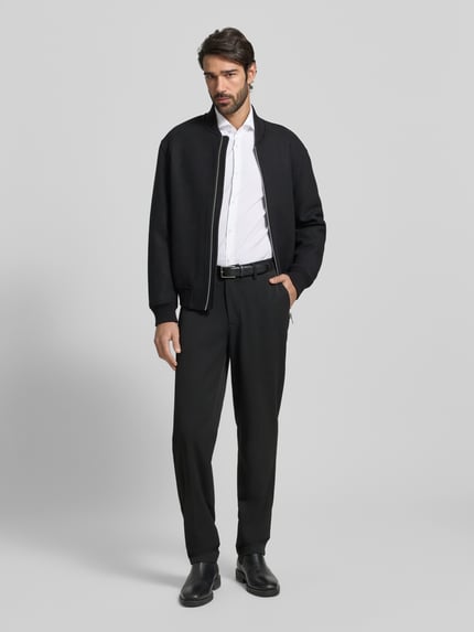 Männermodel trägt Slim Fit Business-Hemd mit Stretch-Anteil Modell 'Hank Hai' von BOSS, Unifarbenes Design, Ganzkörperansicht von vorne.