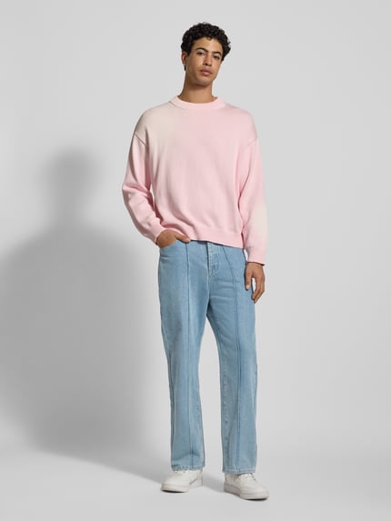 Męski model nosi Wide Fit Jeans mit Längsnähten od ANOTHER COTTON LAB, mieszanka bawełny i wiskozy, wpuszczane kieszenie, jasnoniebieskie, długość wewnętrzna nogawki 73 cm, szerokość w pasie 39 cm, pełny widok z przodu.