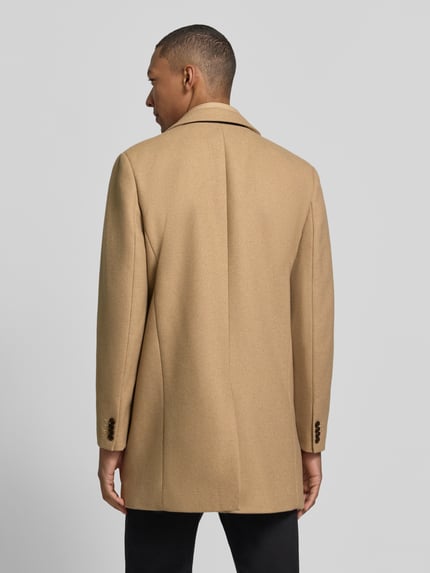 Männermodel trägt Regular Fit Mantel aus Woll-Mix mit Viskose-Anteil von Matinique in Beige, strukturierte Oberfläche, Ganzkörperansicht Rückansicht. Rückenlänge 88 cm, Schulterbreite 46 cm, Brustweite 56 cm, Ärmellänge 67 cm, Stehkragen, Reverskragen, Eingrifftaschen.