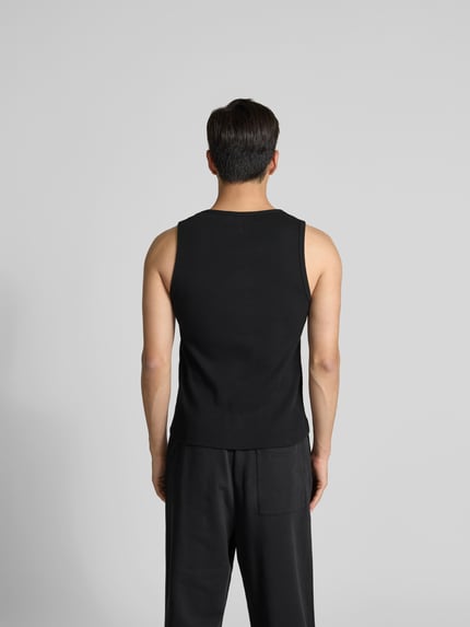 Mężczyzna nosi Top aus reiner Baumwolle od MAISON KITSUNÉ, czarny, prążkowana faktura, krój slim fit, bez rękawów, widok całej sylwetki z tyłu