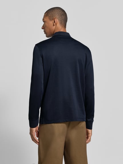 Männermodel trägt Regular Fit Poloshirt aus Baumwoll-Mix mit Brusttasche von bugatti in Dunkelblau, Ganzkörperansicht Rückansicht.