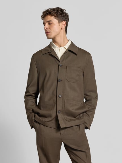 Męski model nosi Regular Fit Hemdjacke mit Woll-Anteil od Filippa K, elastyczna mieszanka materiałów z dodatkiem wełny, krój regular fit, na całej długości listwa guzikowa, nakładane kieszenie na piersi i wpuszczane kieszenie, wykładany kołnierz, długość tyłu w rozmiarze 50: 75 cm, brązowy, tekstura gładka, prostokątne kształty, całkowity widok od przodu.