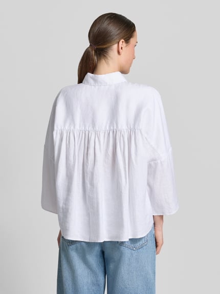 Vrouwenmodel draagt witte linnen blouse met oversneden schouders van Christian Berg Woman, loose fit, kentkraag, knoopsluiting, 3/4-mouw, ruglengte maat 36: 63 cm, mouwlengte maat 36: 54 cm, rugaanzicht.