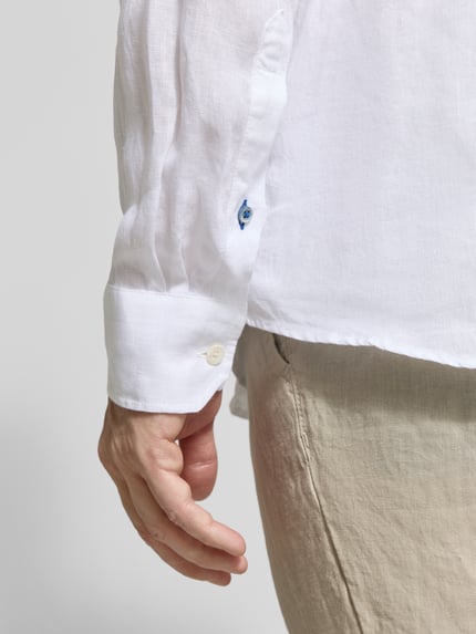 Männermodel trägt Casual Fit Freizeithemd aus Leinen von OLYMP Level Five, weiß, Knopfleiste, Nahaufnahme Unterarm, reine Leinenstruktur. Rückenlänge bei Größe M: 77 cm, Schulterbreite bei Größe M: 49 cm, Ärmellänge bei Größe M: 67 cm.
