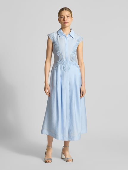 Frauenmodel trägt Hemdblusenkleid aus Modal-Mix mit Spitze Modell 'COLE' von Copenhagen Muse in Hellblau, A-Linie, Ganzkörperansicht von vorne.