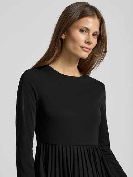 Frauenmodel trägt Maxi-Freizeitkleid im Set mit Strick-Pullunder aus reiner Schurwolle Modell 'EBRO' von Weekend Max Mara, Optik: Unifarben, Loose-Fit, Rundhals, Langarm, Materialverarbeitung: Chiffon und Strick, Farbe Schwarz, Nahaufnahme Oberkörper.