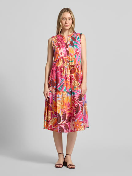 Frauenmodel trägt Midikleid im Stufen-Look von Milano Italy in Pink mit buntem Blumenmuster aus Baumwoll-Mix, taillierte Passform, Serafino-Ausschnitt, Rückenlänge bei Größe 36: 110 cm, Brustweite: 47 cm, Ganzkörperansicht von vorne.