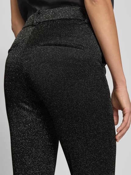Vrouwenmodel draagt Stoffhose in verkürzter Passform Modell 'FRANCOISE' van Cambio, zwart met glittereffect, detailopname heupen. Materiaalmix met viscose, elastische taille, Franse steekzakken, rechte snit, verkorte pasvorm.