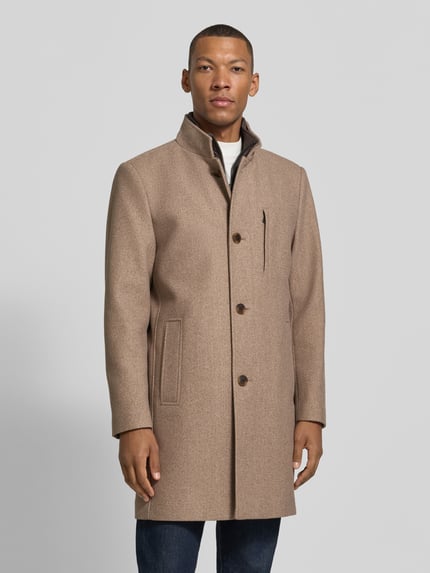 Mężczyzna nosi Regular Fit płaszcz z stójką i wpuszczanymi kieszeniami Regular Fit Mantel mit Stehkragen und Eingrifftaschen von ROY ROBSON, beżowy odcień, gładka tekstura, Listwa guzikowa, Długość tyłu w rozmiarze 50: 96 cm, Szerokość ramion w rozmiarze 50: 45 cm, Szerokość klatki piersiowej w rozmiarze 50: 47 cm, Długość rękawów w rozmiarze 50: 67 cm, Ganzkörperansicht von vorne.
