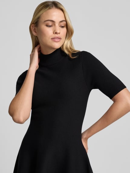 Frauenmodel trägt Minikleid aus Viskose-Mix mit Stehkragen von Apricot, A-Linie, 1/2-Arm, Schwarz, Nahaufnahme Oberkörper. Rückenlänge 35 cm, Brustweite 40 cm, Ärmellänge 30 cm.