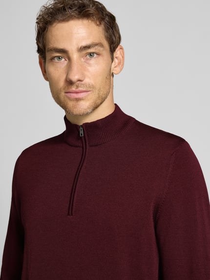 Männermodel trägt Regular Fit Sweatshirt aus reiner Schurwolle von MAERZ Muenchen, bordeauxrot, strukturierte Oberfläche, Troyer-Kragen, elastische Abschlüsse, reine Schurwolle, krój regular fit, Nahaufnahme Oberkörper.