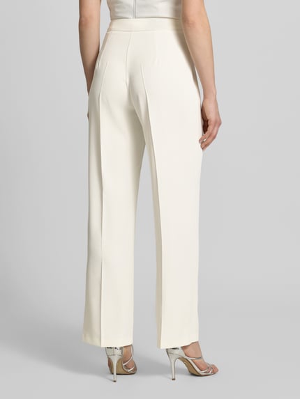 Frauenmodel trägt Hose mit Bügelfalten von Jake*s Cocktail in Creme, Material-Mix mit Stretch, Regular Fit, Ganzkörperansicht Rückansicht.