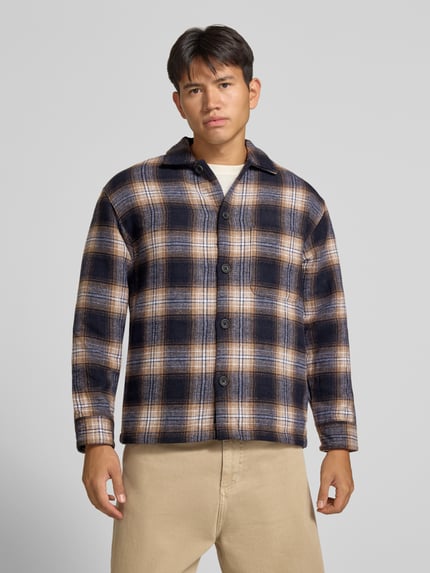 Männermodel trägt Regular Fit Hemdjacke mit Brusttasche Modell 'SOHO OLLIE' von JACK & JONES, kariert, Vorderansicht, Nahaufnahme Oberkörper. Kontext: Herren Hemdjacke mit Kentkragen, durchgehende Knopfleiste, Rückenlänge bei Größe M 71 cm, Schulterbreite 41 cm, Ärmellänge 65 cm.