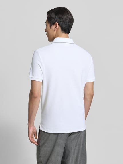 Männermodel trägt poloshirt mit logo stitching aus reiner katoen van CK Calvin Klein, look: effen, regular fit, polokraag, korte mouw, puur katoen, ganzkörperansicht rückansicht.