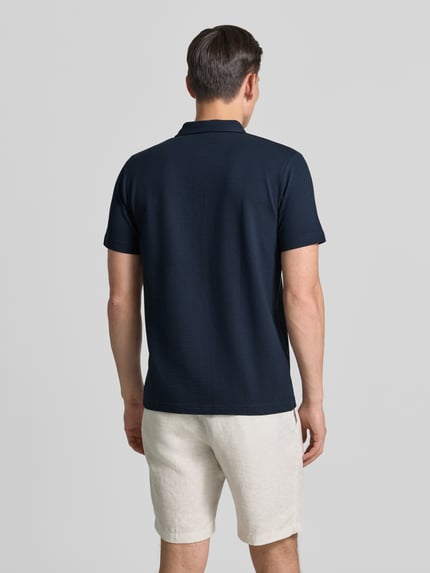 Männermodel trägt Regular Fit Poloshirt mit Logo-Stitching von Lerros in Dunkelblau, Baumwoll-Mix mit Stretch-Anteil, Strukturmuster, Ganzkörperansicht Rückansicht. Rückenlänge bei Größe M: 70 cm.