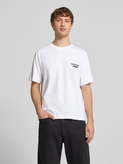 Männermodel trägt Herren T-Shirt mit Statement-Print Modell 'NORREBRO' von Jack & Jones aus reiner Baumwolle, weiß, gerader Schnitt, Rundhalsausschnitt, Ganzkörperansicht von vorne.