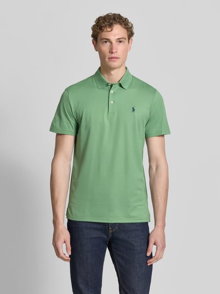 Męski model nosi koszulkę polo Tailored Fit Poloshirt mit Label-Stitching od Ralph Lauren, mieszanka bawełny, Listwa guzikowa, Długość tyłu w rozmiarze M: 73 cm, Długość rękawów w rozmiarze M: 21 cm, kolor zielony, gładka faktura, Ganzkörperansicht von vorne