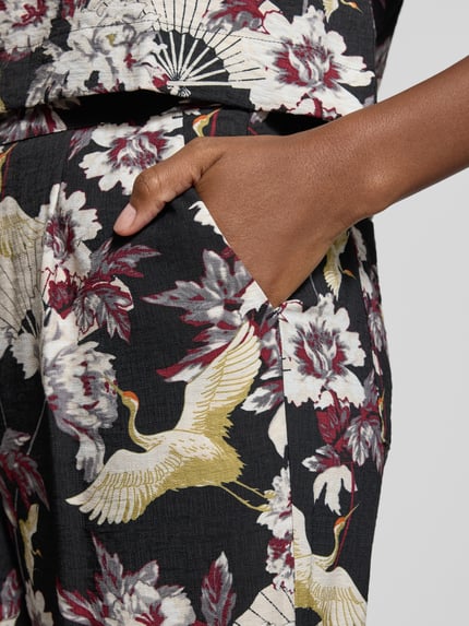 Vrouwenmodel draagt Stoffhose aus Viskose-Mix Modell 'Orelia' van GUIDO MARIA KRETSCHMER WOMAN met wijde pijpen, allover bloemenprint, detailopname heup.