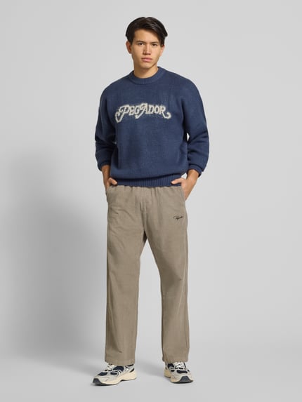 Mannelijk model draagt Stoffhose met elastische tailleband van Pegador, beige katoen, losse pasvorm, steekzakken, volledig frontaal.