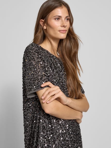 Vrouwenmodel draagt Knielanges Kleid met Rundhalsausschnitt van Comma, los model, knielengte, met pailletten, met korte mouwen, close-up bovenlichaam.